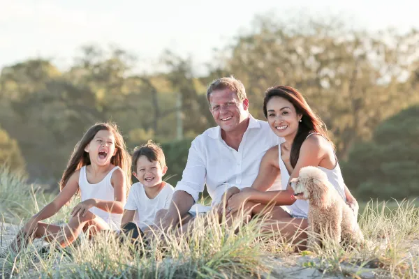 Family sitting in grass field together outdoors
